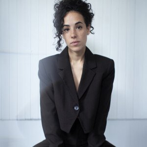 Sarah Charles pose en costume noir ©CapucinedeChocqueuse
