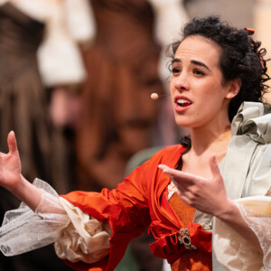 Sarah Charles chante sur scène en costume d'époque